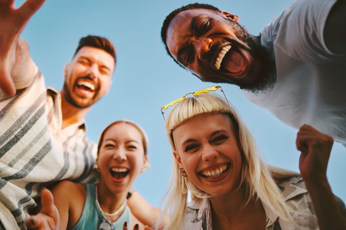 Four cheerful multi-ethnic friends having fun outdoors